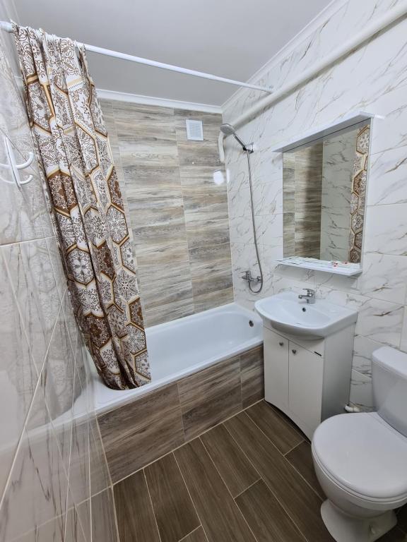 uma casa de banho com um WC, uma banheira e um lavatório. em Квартира посуточно в центре г.Петропавловска em Petropavl