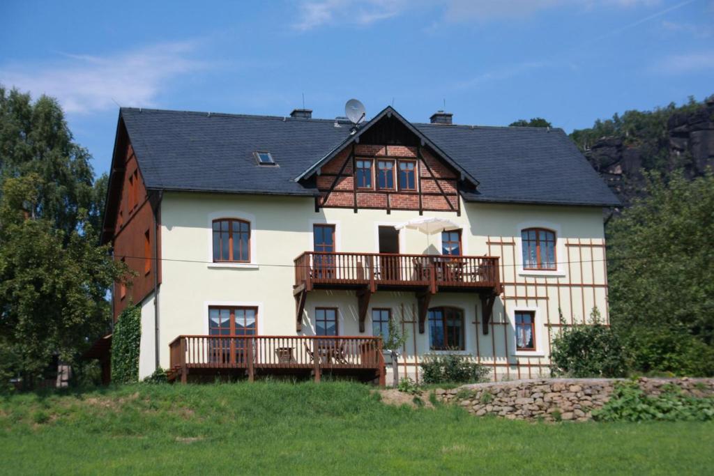 een groot wit huis met een zwart dak bij Ferienhof Schönfelder in Königstein an der Elbe