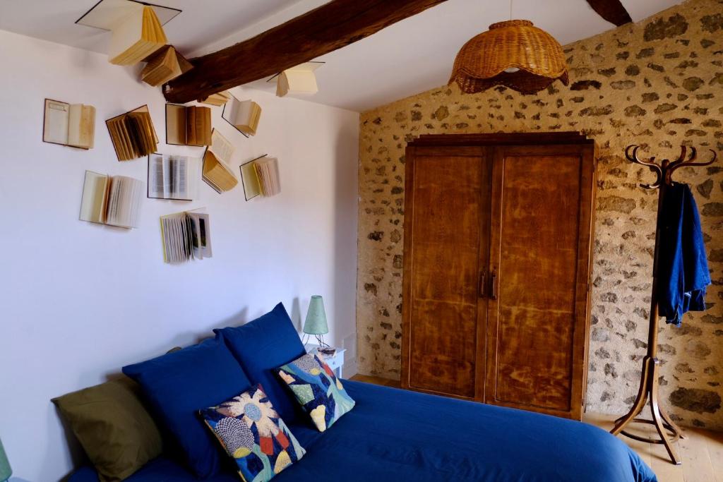 a room with a blue couch and some books on the wall at Le Clou in Chauvigny