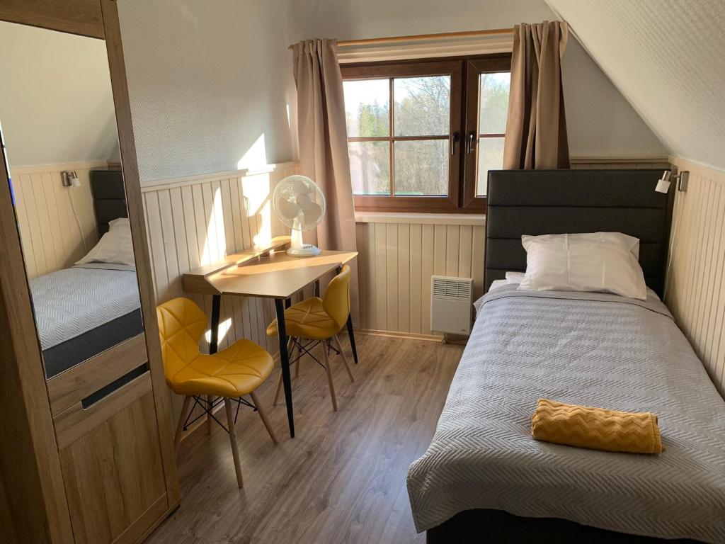 a bedroom with a bed and a desk and a table at Keldrimäe külalistemaja in Hiiumaa