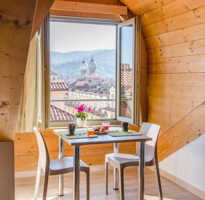 Turin Sweet Home في تورينو: طاولة وكراسي في غرفة مع نافذة كبيرة