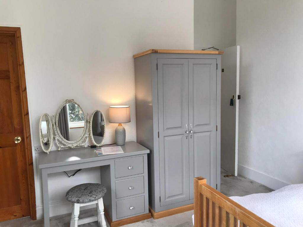 a bedroom with a dressing table and a mirror at Cornerways in Ventnor