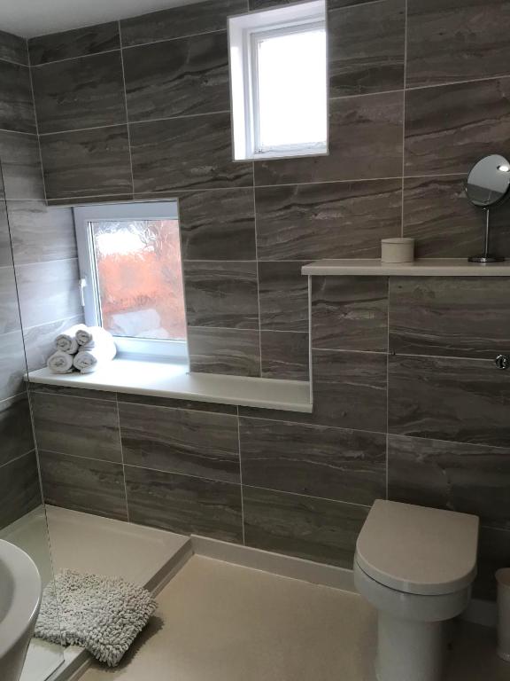 a bathroom with a toilet and a window at Cornerways in Ventnor
