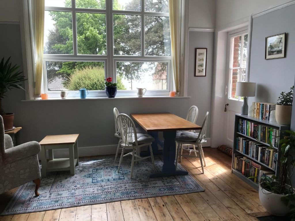 a dining room with a table and chairs and a window at Cornerways in Ventnor