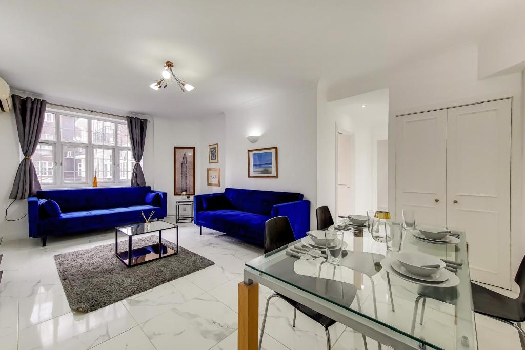 a living room with blue couches and a glass table at The Princes Boutique in London