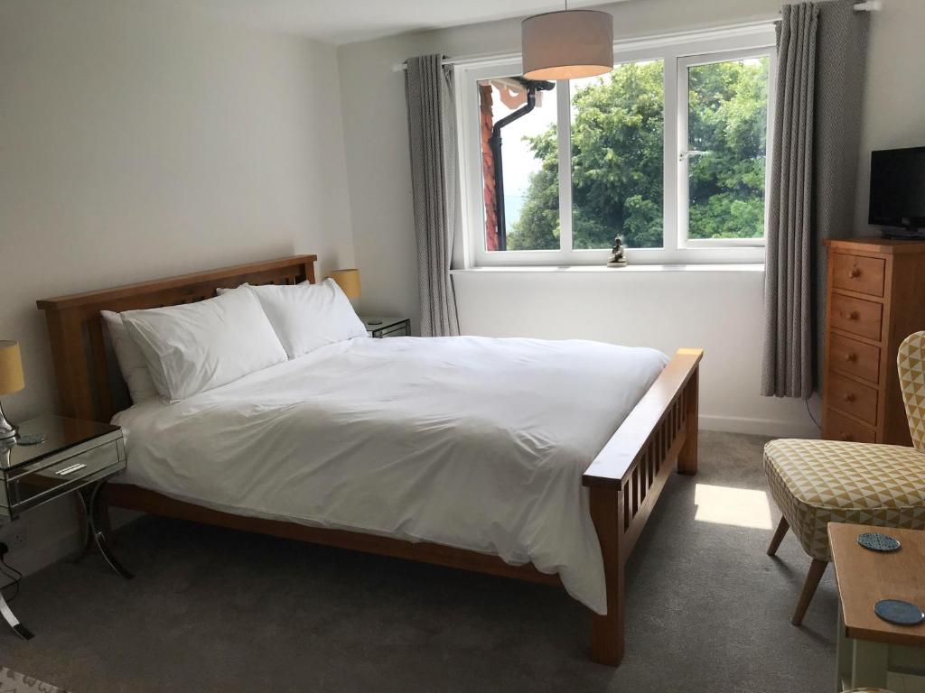 a bedroom with a large bed and a window at Cornerways in Ventnor