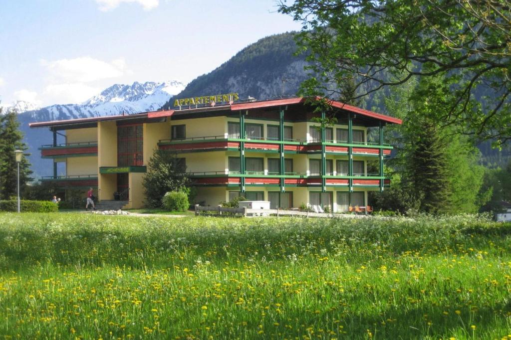 un edificio con un campo delante de él en Apartment at the Achensee with balcony or terrace, en Lago Achen