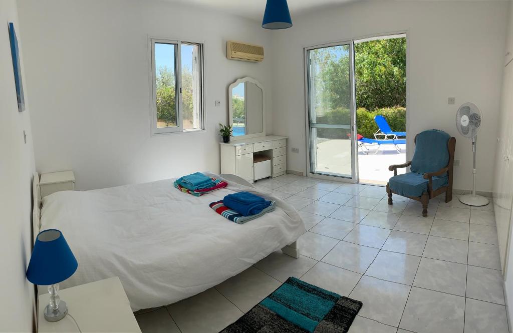 een slaapkamer met een bed, een bureau en een stoel bij Paphos Apartment with Private Pool in Mesoyi