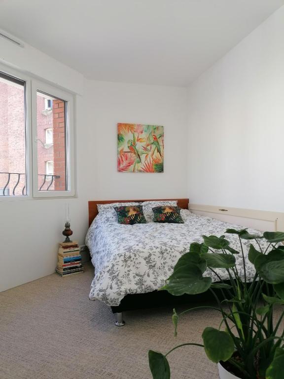 a bedroom with a bed and a painting on the wall at DUNKE in Dunkerque