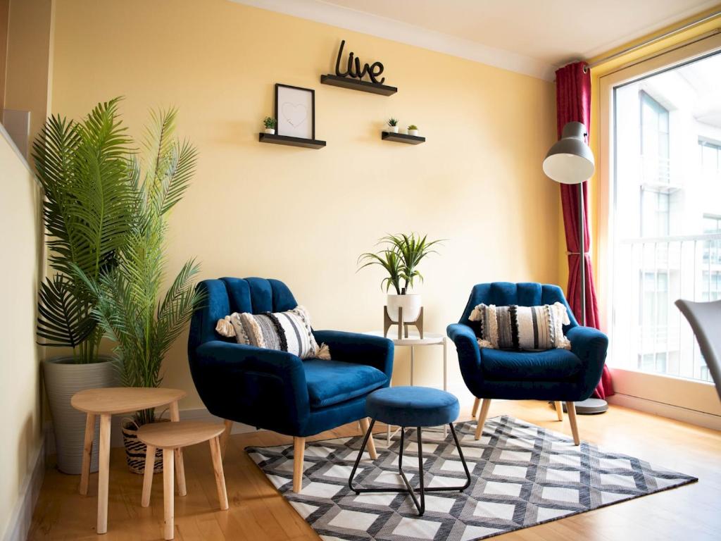 a living room with two blue chairs and a rug at Pass the Keys Lovely 2-bed in Perfect City Location with Parking in Glasgow