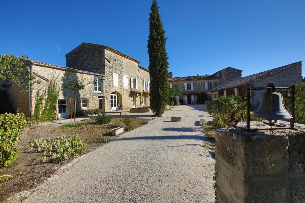 una calle en un pueblo con una campana en la pared en Prieuré de Grignan, en Grignan