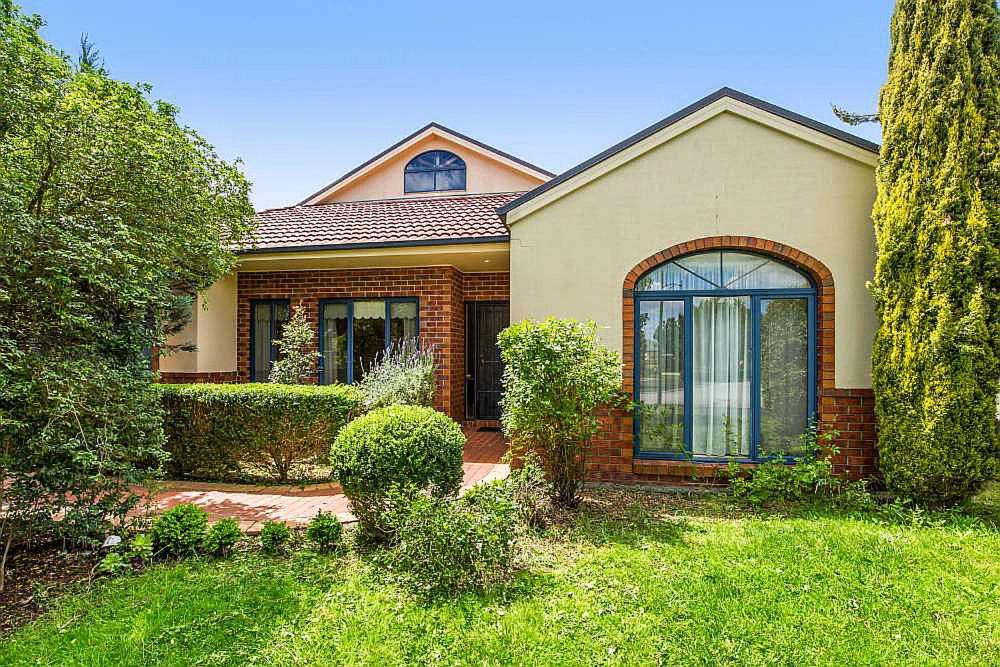 a brick house with a large window in a yard at Vacation Getaway in Rowville