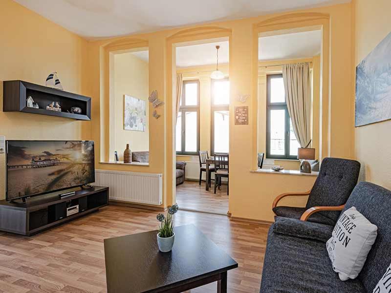 Una sala de estar con un sofá y un televisor. en Strandvilla Ostpreussen - Dependance Strandhus, en Ahlbeck