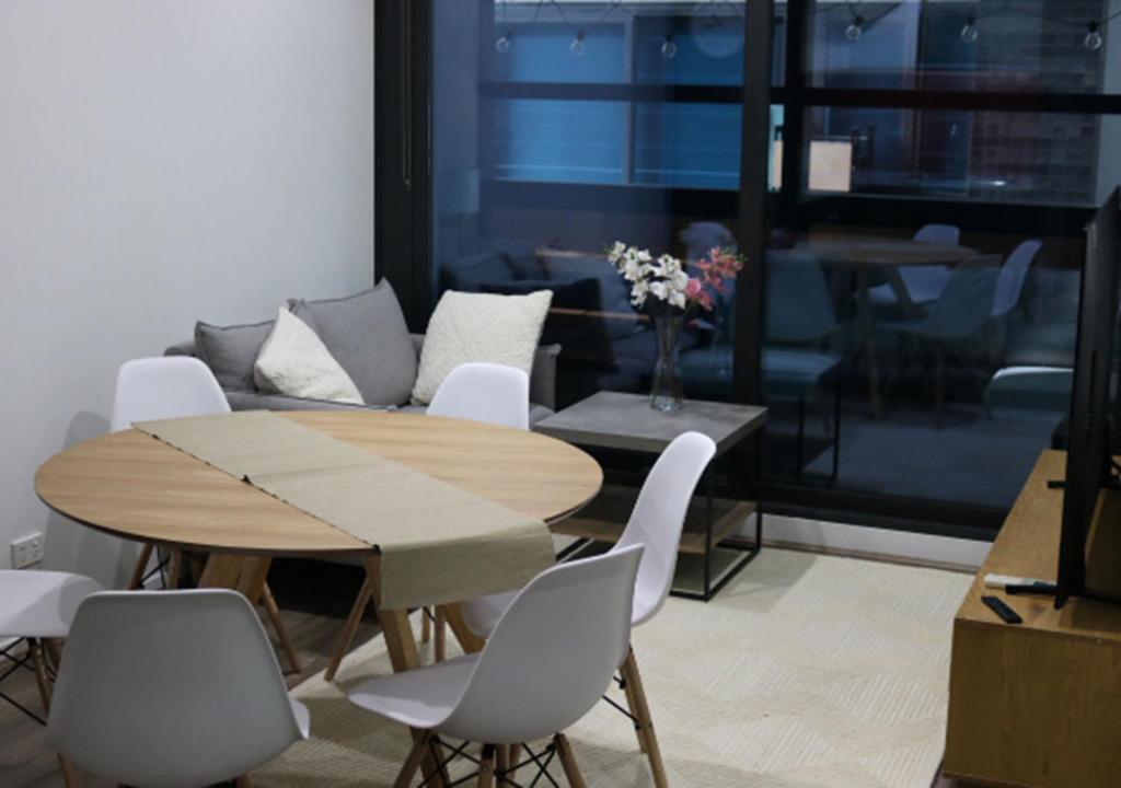 a dining room with a table and chairs and a couch at MELBOURNE STAR APARTMENT in Melbourne