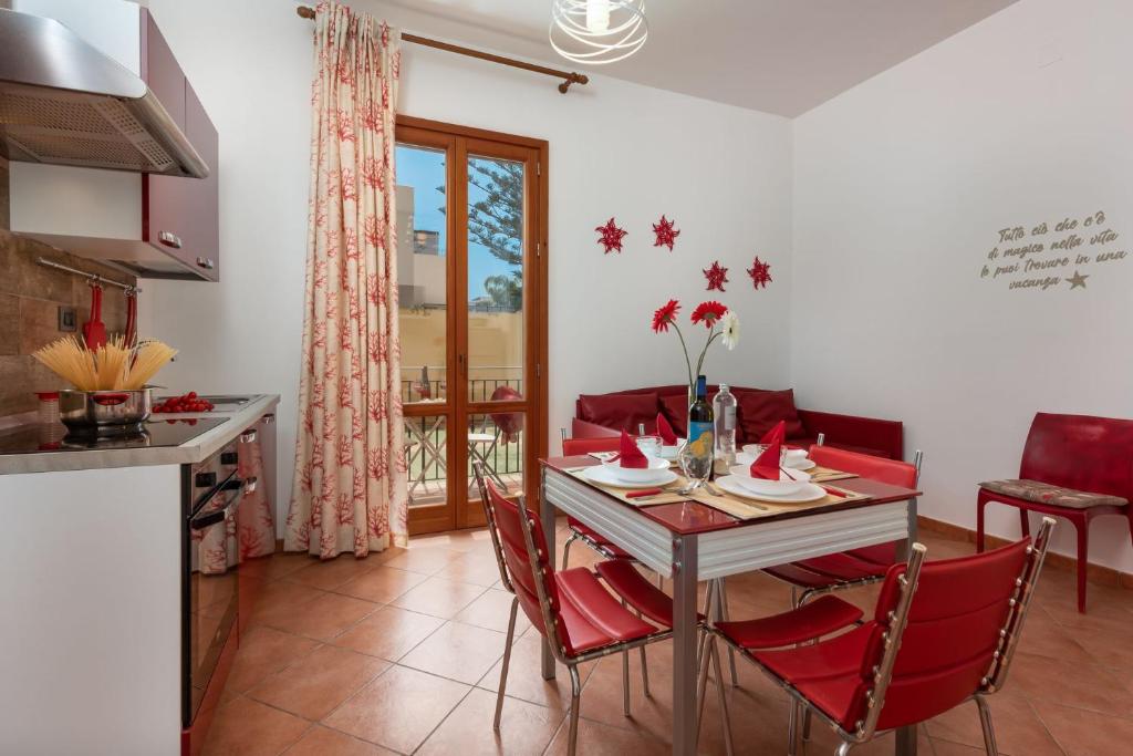 eine Küche und ein Esszimmer mit einem Tisch und Stühlen in der Unterkunft Residence I Tesori di San Vito in San Vito lo Capo