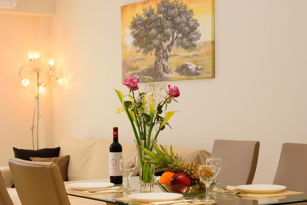 - une table à manger avec un vase de fleurs dans l'établissement Melia deluxe city view apartment, à Agios Nikolaos