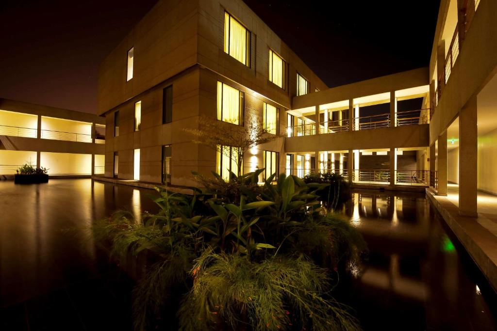 a large building with a pool in front of it at night at Hyatt Place Hampi in Hampi