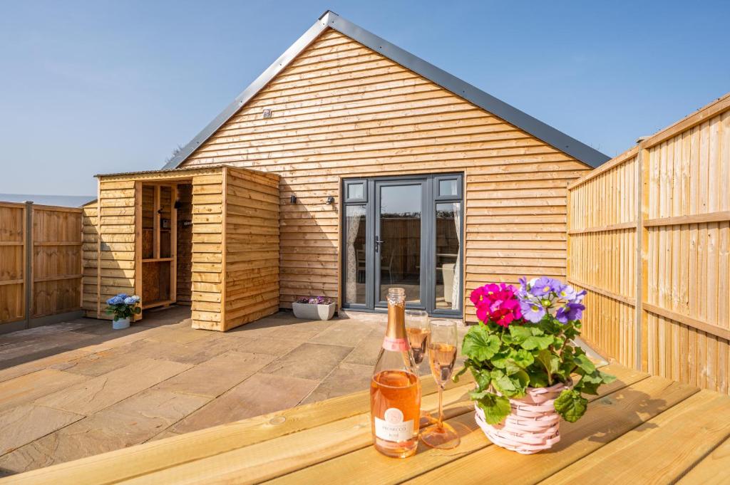 a wooden house with a patio with flowers on it at Luxury, Spacious Cottage in the Black Mountains in Hereford