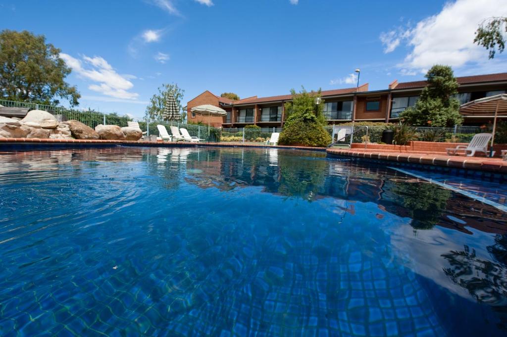 une grande piscine d'eau bleue en face d'un bâtiment dans l'établissement Club Mulwala Resort, à Mulwala