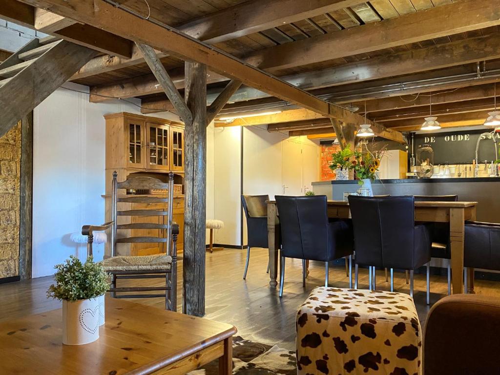 una habitación con una mesa y sillas y un bar en Herberg Boerderij de Straat-Hof en Leimuiden