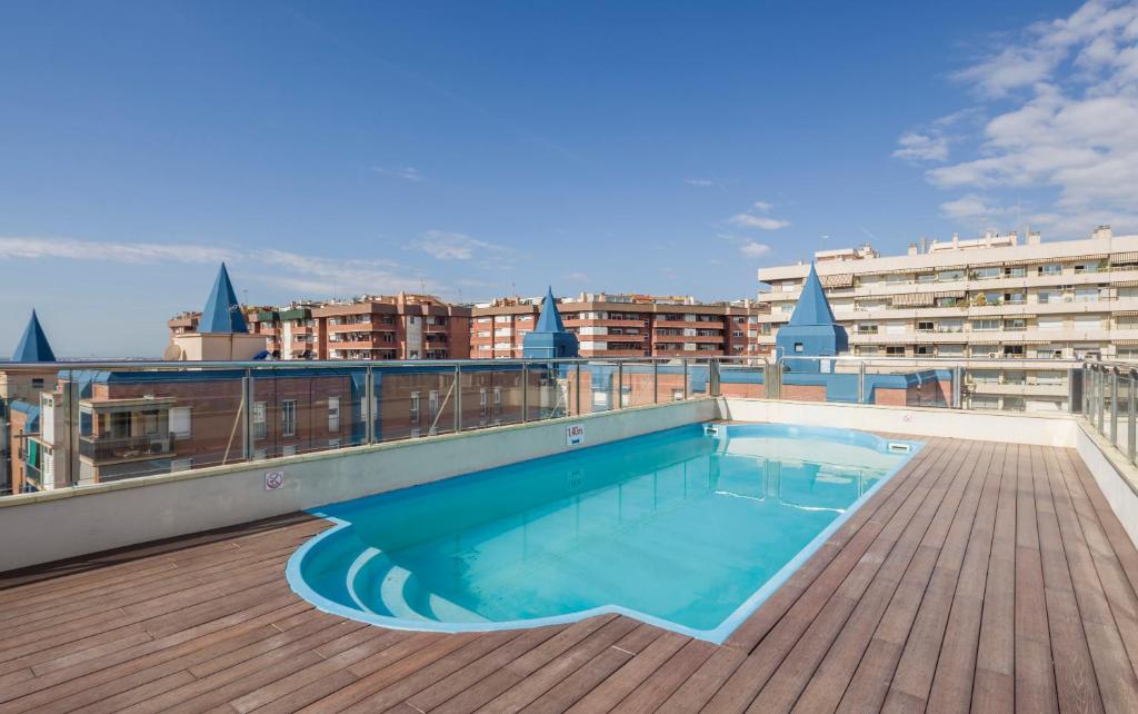 a large swimming pool with a balcony overlooking the ocean at Ilunion Les Corts Spa in Barcelona