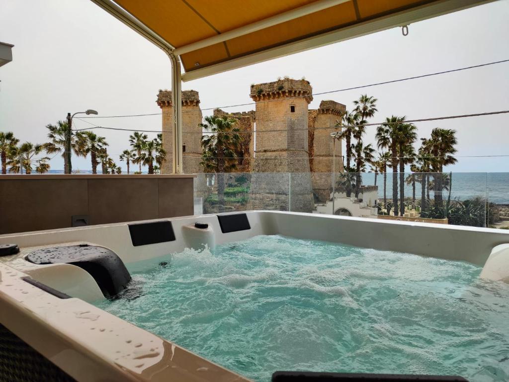 a hot tub on a balcony with a view of the ocean at Residenza 4 Colonne CONTEMPORANEA in Santa Maria al Bagno