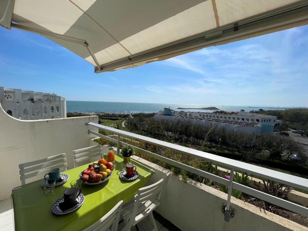 - une table avec des fruits sur un balcon avec vue sur l'océan dans l'établissement Studio Les Terrasses de la Mer-9 by Interhome, à La Grande Motte
