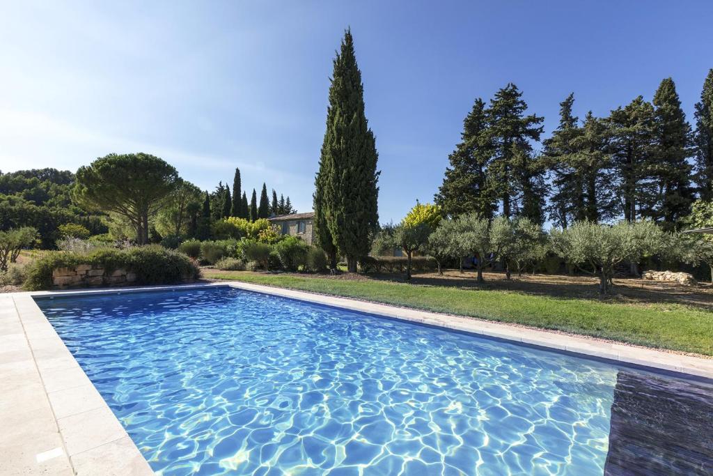 einen Pool in einem Garten mit Bäumen in der Unterkunft Villa de 4 chambres avec piscine privee jardin clos et wifi a Beaumes de Venise in Beaumes-de-Venise