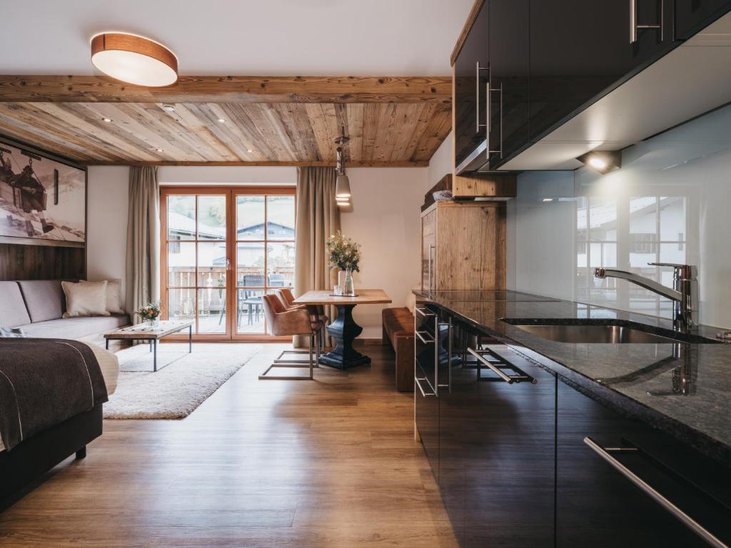 a kitchen with a sink and a living room at VAYA Kaprun inklusive Zell am See Kaprun Sommer Karte in Kaprun