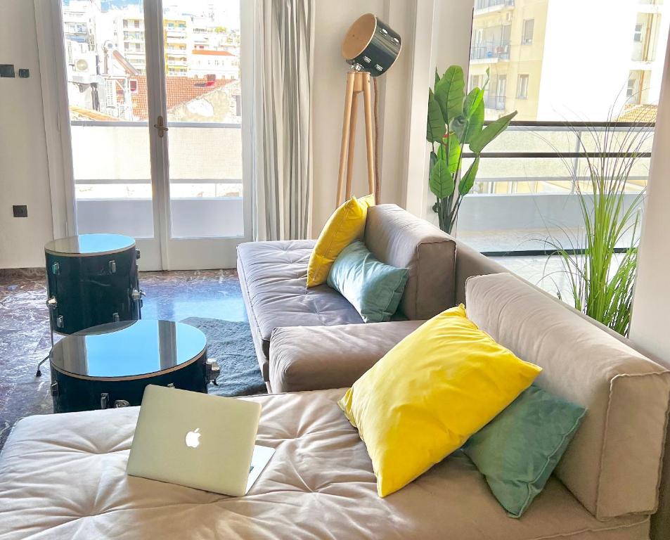 a living room with a couch with a laptop on it at Happy Place! Big, Bright & Central - Ideal for families and groups of friends in Patra