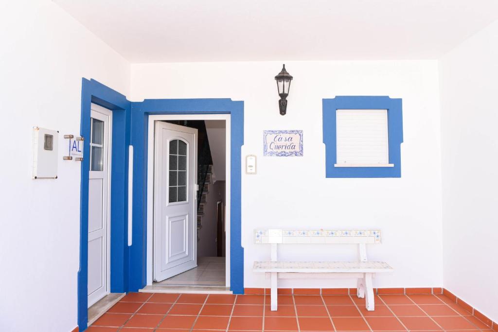 un couloir avec des murs bleus et blancs et un banc dans l'établissement Casa Querida, à Óbidos