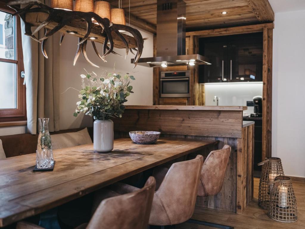 a kitchen and dining room with a wooden table and chairs at VAYA Kaprun inklusive Zell am See Kaprun Sommer Karte in Kaprun