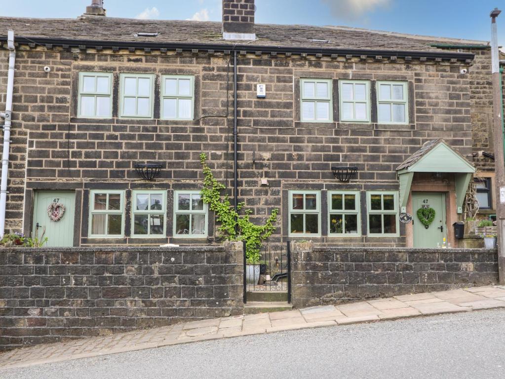 una casa de ladrillo al lado de una calle en Greenfield Cottage en Oakworth