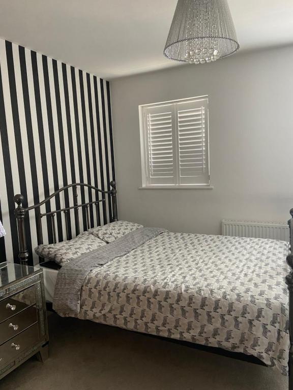 伍爾弗漢普頓的住宿－Captivating 2-Bed House in Wolverhampton，一间卧室配有两张床和吊灯。