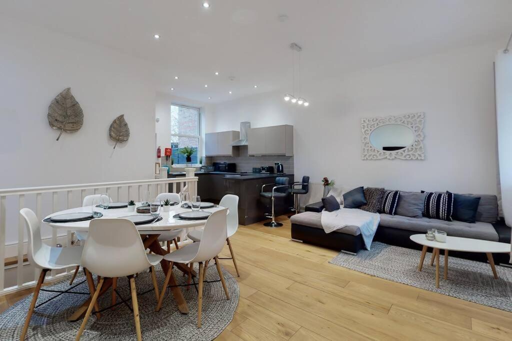 un soggiorno con tavolo e divano di Lovely 2 Bedroom Apartment near Highgate Station a Londra