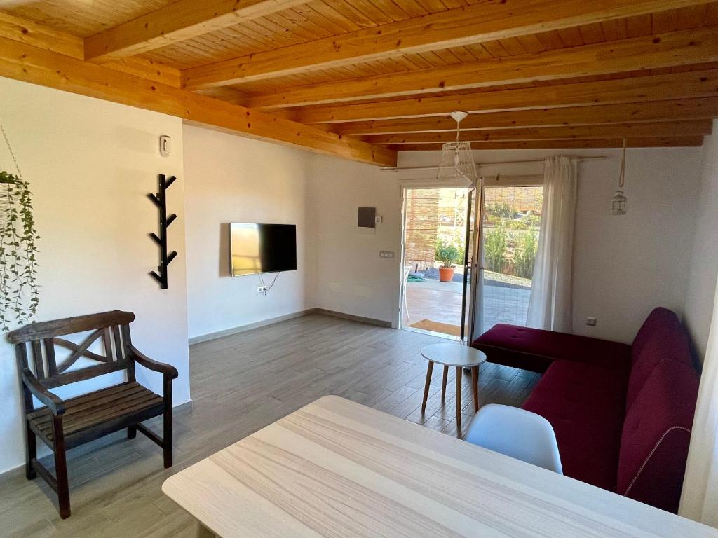 een woonkamer met een rode bank en een tafel bij La Casita de la Era in Betancuría