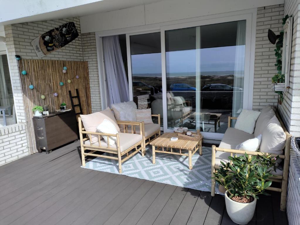 een patio met stoelen en een tafel op een veranda bij Ons Strandhuis in IJmuiden