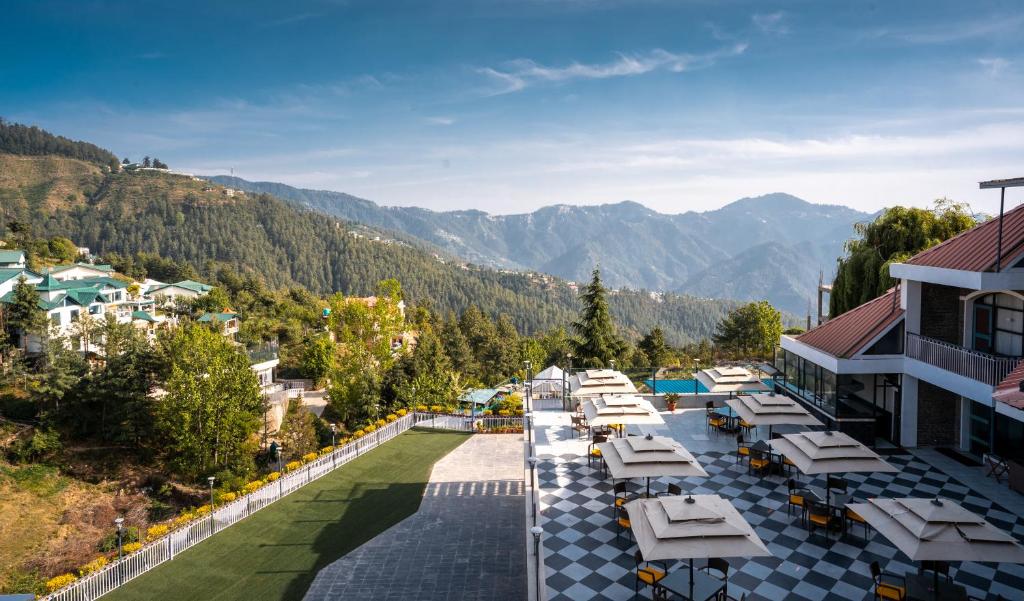 - une vue aérienne sur un complexe avec des tables et des chaises dans l'établissement Marigold Sarovar Portico Shimla, à Shimla