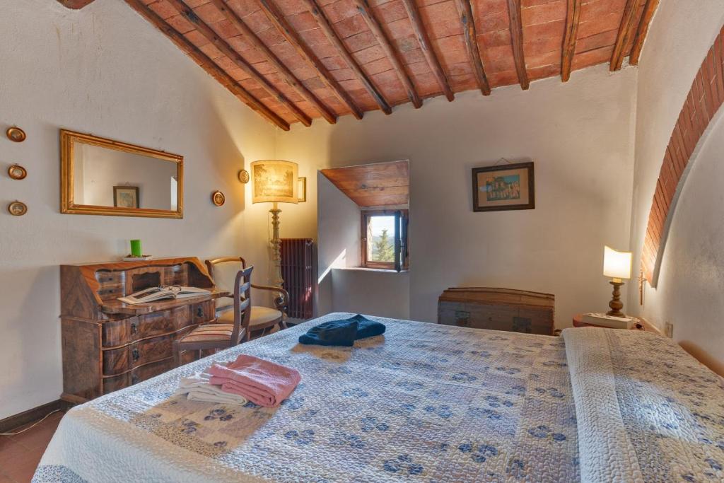 sypialnia z dużym łóżkiem i biurkiem w obiekcie Castello di Monteluco a Lecchi w mieście Gaiole in Chianti