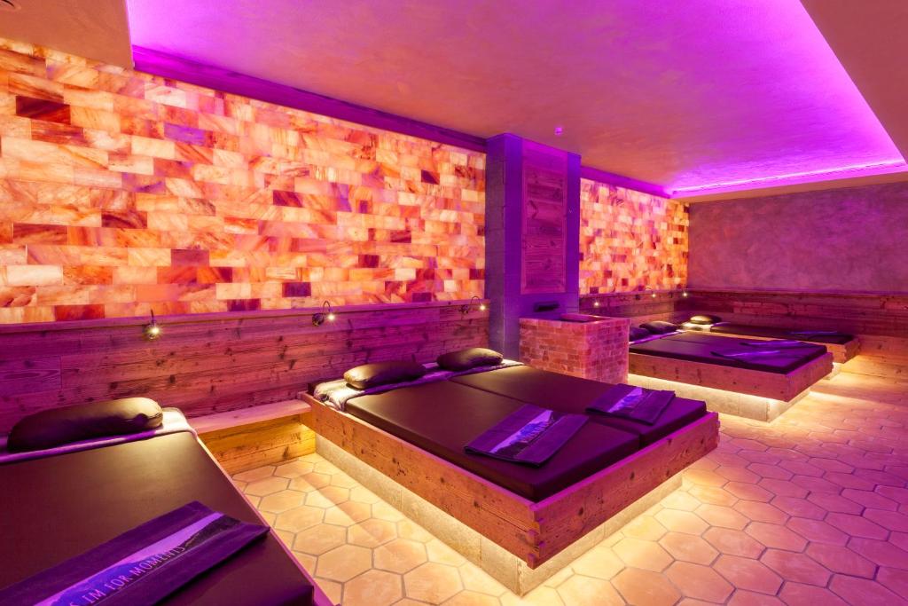 a room with two beds and purple lighting at FOR MOMENTS Apartments & Spa in Roßhaupten