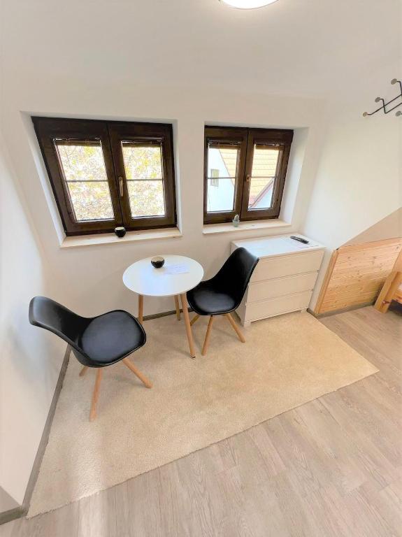 a room with two chairs and a table and some windows at Pension Adel in Český Krumlov