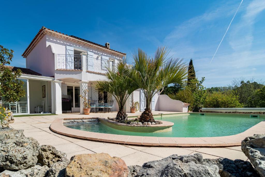eine Villa mit einem Pool und einem Haus in der Unterkunft Les Vergers in Gonfaron