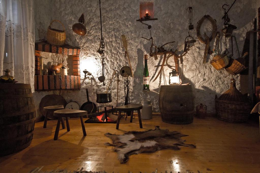 um quarto com uma lareira, uma mesa e cadeiras em Sailor's Rustic House em Virpazar