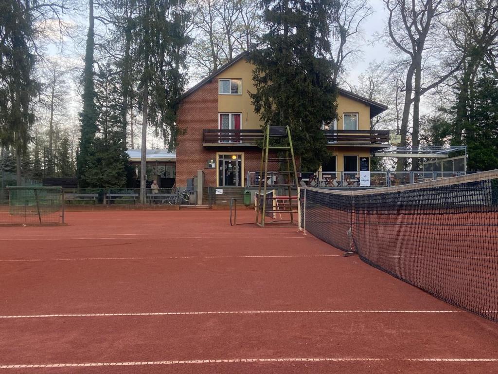 una pista de tenis frente a un edificio en Hotel Houštka, en Brandýs nad Labem-Stará Boleslav