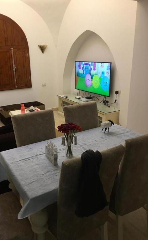 a living room with a table with chairs and a tv at j16 in Hurghada