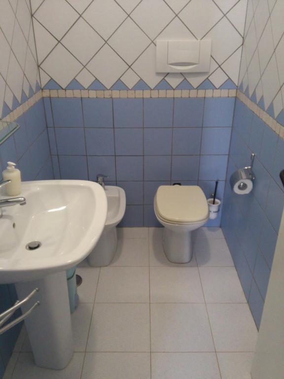 niebiesko-biała łazienka z toaletą i umywalką w obiekcie Villetta Porto Selvaggio w mieście Nardò