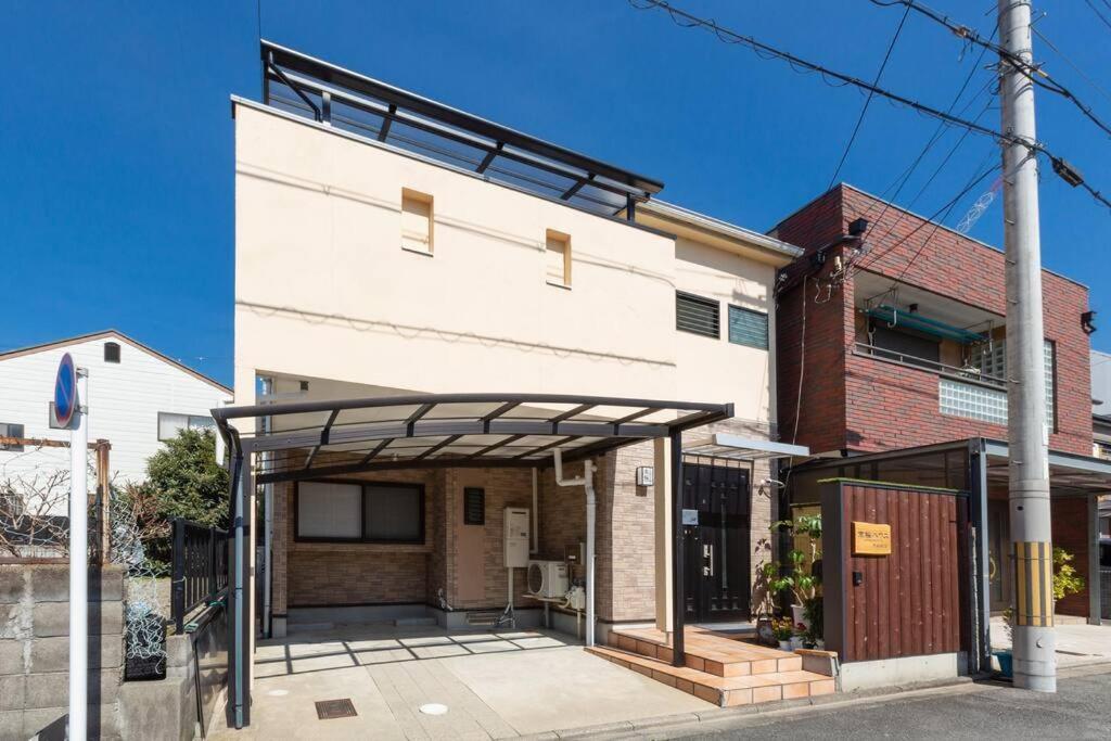 a white building with awning on the side of it at KYO SAKURA HOUSE in Kyoto