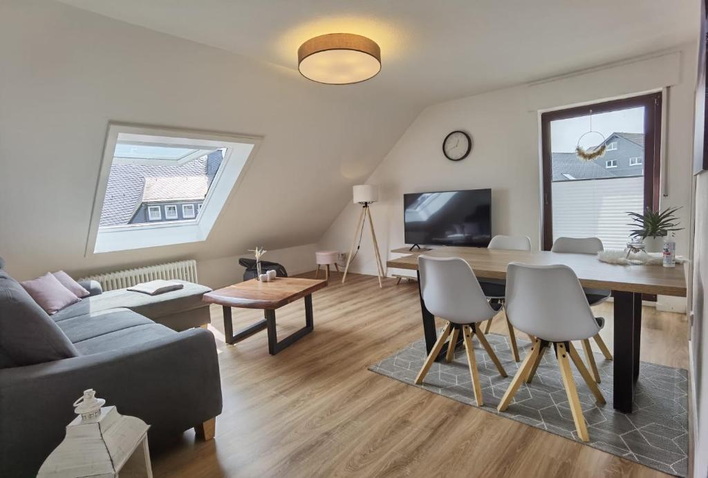 a living room with a couch and a dining room table at Winterberg Centrum with SommerCard and bicycle cellar in Winterberg