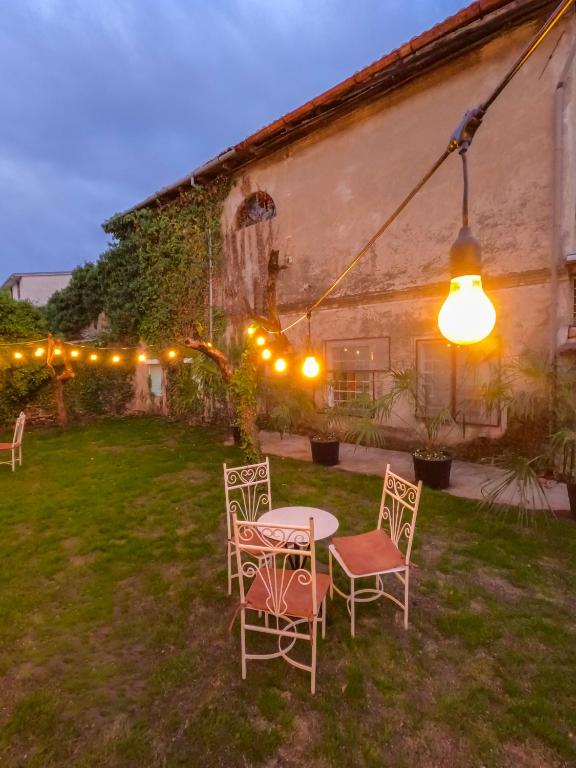 a table and chairs in a yard at night at InTown Guesthouse Shkoder in Shkodër