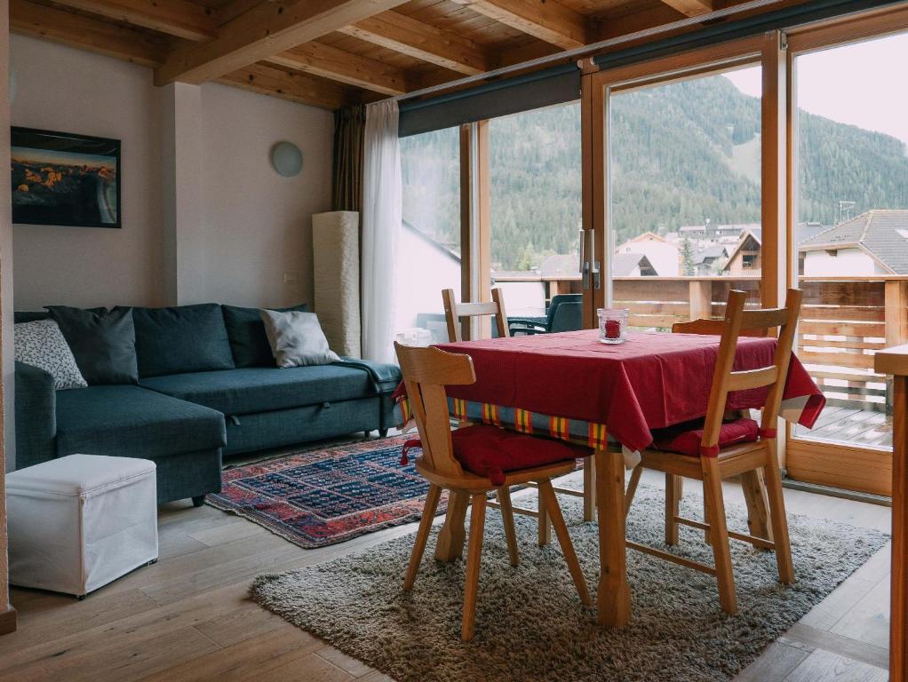 a living room with a table and chairs and a couch at Ciasa Irene App Mansarde in La Villa